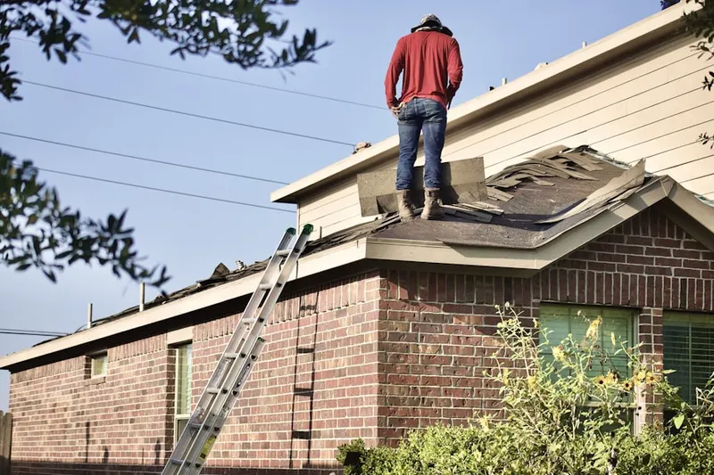 Professional roofer working on a residential roof in Willow Manor Farms